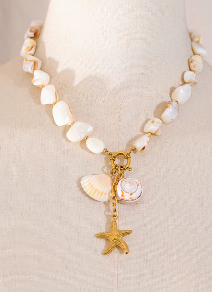 Necklace with shell and starfish charms on a mannequin bust.